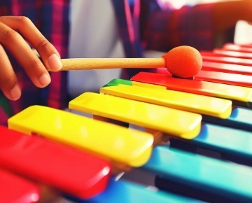 Musiker spielt auf einem bunten Xylophon