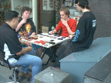 Eine Gruppe junger Männer, die das Yu-Gi-Oh! Sammelkartenspiel spielen